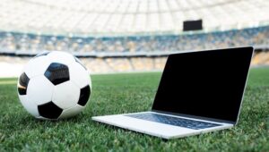 Notebook em estádio de futebol com uma bola ao lado