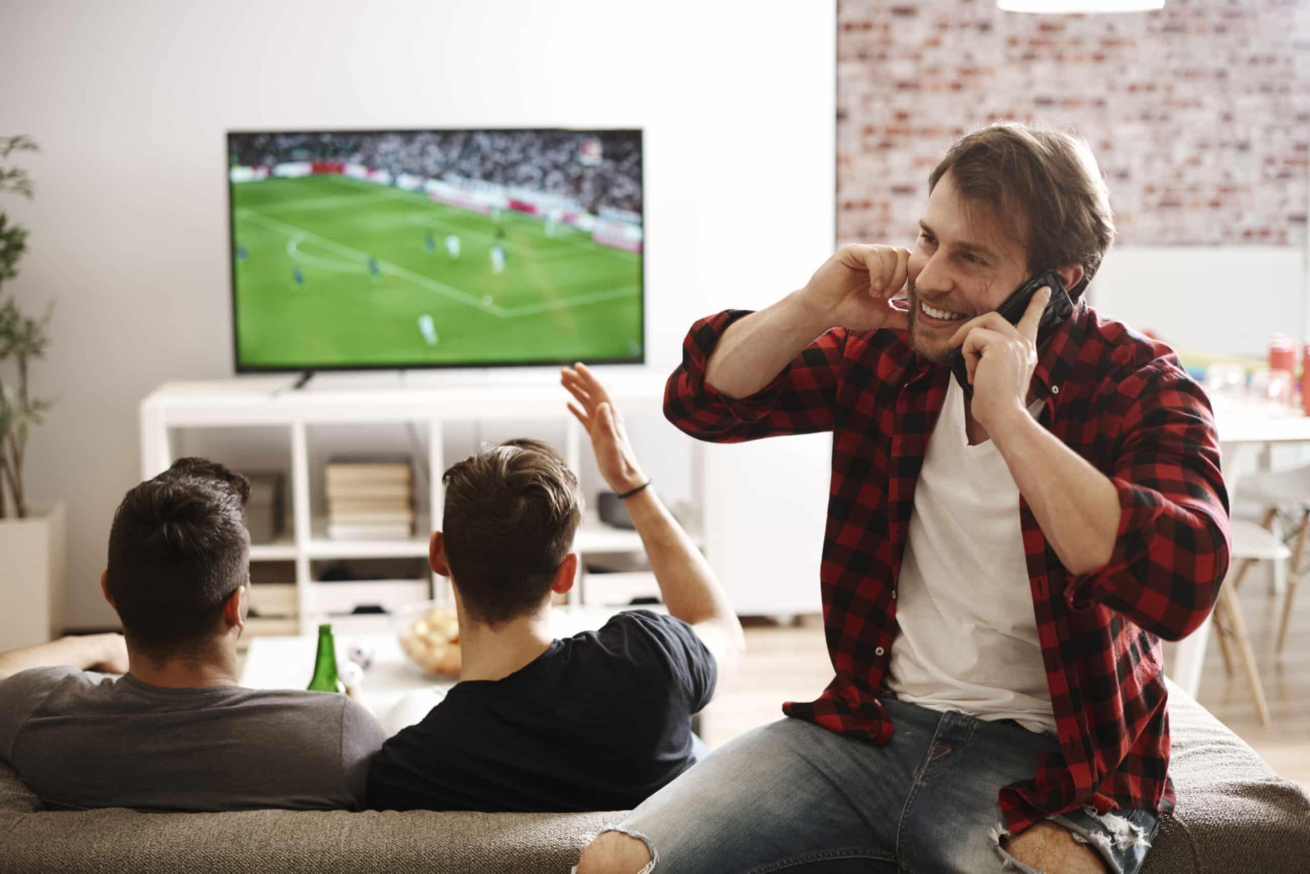 man-talking-by-phone-while-soccer-match